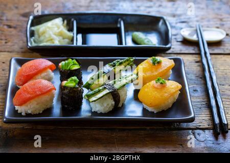 Selezione di sushi vegani con pomodori, melanzane, asparagi e pepe Foto Stock