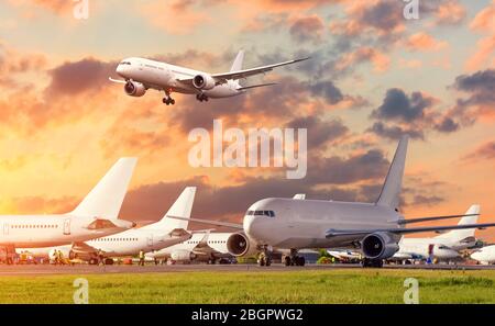 Vista degli aerei in piedi all'aeroporto e l'approccio aereo all'atterraggio nel cielo Foto Stock