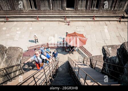 I turisti salgono le scale ripide e i gradini per raggiungere i vari punti di osservazione intorno ai templi di Angkor Wat, provincia di Siem Reap, Cambogia. Foto Stock