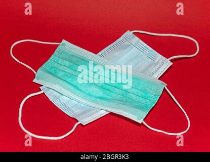 Maschere respiratorie monouso isolate su sfondo rosso Foto Stock
