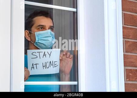 L'uomo in maschera medica rimane a casa. Autoisolamento. Foto Stock
