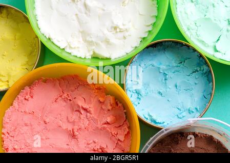 Vista ravvicinata di diverse tovole di plastica colorate con vari frutti di bosco multicolore, frutta e cioccolato fresco gelato fatto in casa naturale come un retrgr Foto Stock