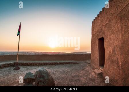 Dhayah Fort nel nord Ras al Khaimah Emirati Arabi Uniti. Golfo, architettura del patrimonio al tramonto Foto Stock