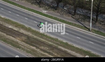 Vista dall'alto del ragazzo di consegna di cibo con grande borsa termica verde in strada Foto Stock