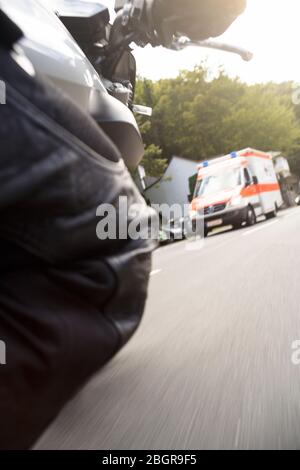 Moto curva di guida con ambulanza in background Foto Stock