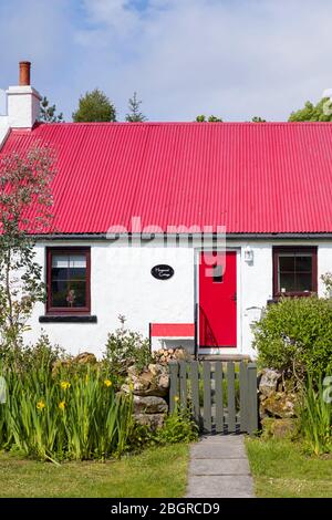 Caratteristico cottage tradizionale imbiancato a calce con luminoso porta di fronte rosso e tetto in ferro ondulato a Kilberry, Argyll e Bute, Scozia Foto Stock