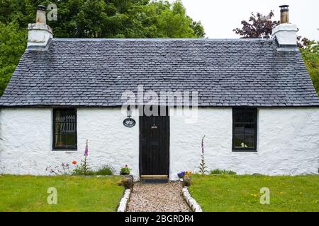 Caratteristico cottage tradizionale imbiancato a calce con porta anteriore nera e tetto piastrellato a Port Appin, Argyll e Bute, Scozia Foto Stock