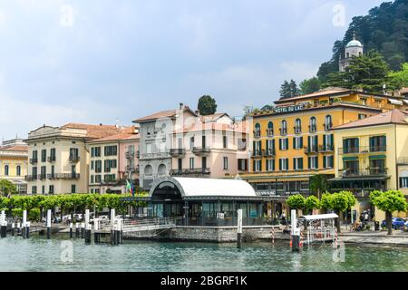 BELLAGIO, LAGO DI COMO, ITALIA - 2019 GIUGNO: Il lungolago e il traghetto sul lago di Como. Foto Stock