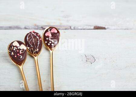 Cucchiai di cioccolato gustoso per feste su un vecchio tavolo di legno Foto Stock