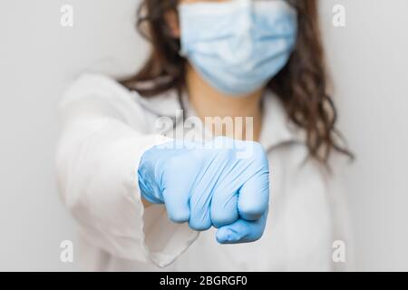 Stop SARSCoV, virus 2020, virus cinese COVID-19. Le donne mano in blu guanti medici mostra pugno. Concetto di protezione contro l'HIV. Medico in blu Foto Stock