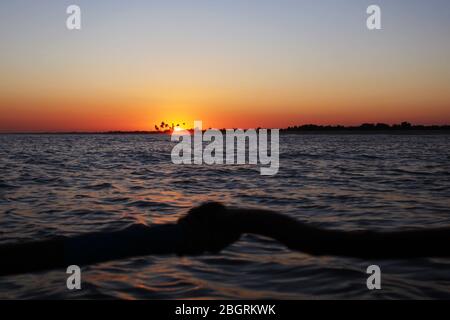 Siling su una tradizionale canoa outrigger malgascio al largo della costa occidentale del Madagascar, a nord di Belo sur Mer, all'alba. Foto Stock