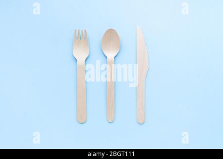utensili da cucina monouso ecologici su sfondo blu. forchette e cucchiai in legno. ecologia, concetto zero rifiuti. vista dall'alto. disposizione piatta Foto Stock