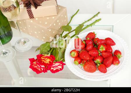 Vita romantica con champagne, fragole e rose in camera Foto Stock