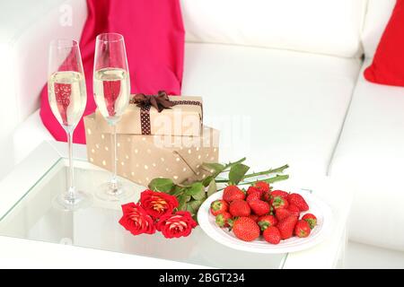 Vita romantica con champagne, fragole e rose in camera Foto Stock