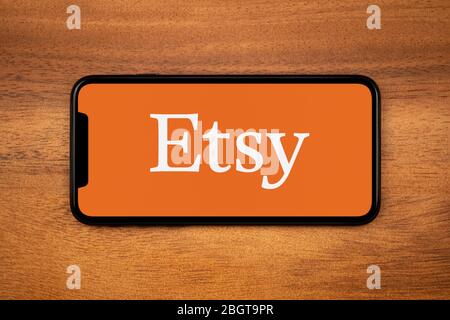 Uno smartphone con il logo Etsy è appoggiato su un tavolo di legno (solo per uso editoriale). Foto Stock