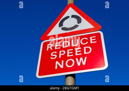 Segnali stradali, rotatoria e Riduci Speed Now, Londra, Regno Unito Foto Stock