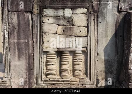 Antiche rovine e antichi dettagli di architettura sulle pareti di Bayon, riccamente decorato Khmer buddista Tempio, Angkor Wat Cambogia Foto Stock