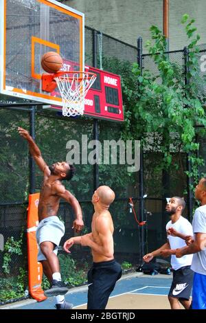 Giocatori dilettanti che si scrambling per la palla sotto il tabellone mentre giocano a basket in 'The Cage', West 4th Street Courts, Manhattan il 29 LUGLIO 2019 i Foto Stock