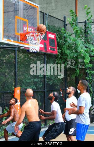 Giocatori dilettanti che si scrambling per la palla sotto il tabellone mentre giocano a basket in 'The Cage', West 4th Street Courts, Manhattan il 29 LUGLIO 2019 i Foto Stock