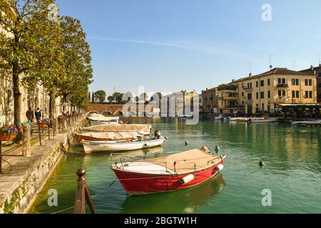 Vista sul canale di mezzo nel centro storico (Sito UNESCO) con il Ponte dei Voltoni (XVI sec.), Peschiera del Garda, Verona, Italia Foto Stock