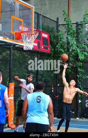 Giocatori dilettanti che si scrambling per la palla sotto il tabellone mentre giocano a basket in 'The Cage', West 4th Street Courts, Manhattan il 29 LUGLIO 2019 i Foto Stock