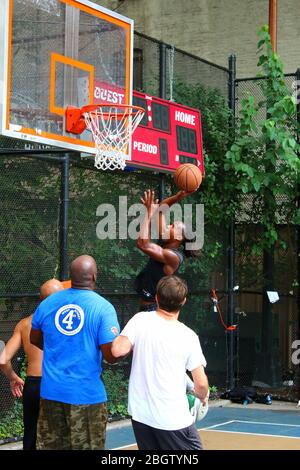 Giocatori dilettanti che si scrambling per la palla sotto il tabellone mentre giocano a basket in 'The Cage', West 4th Street Courts, Manhattan il 29 LUGLIO 2019 i Foto Stock