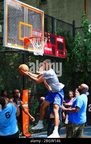 Giocatori dilettanti che si scrambling per la palla sotto il tabellone mentre giocano a basket in 'The Cage', West 4th Street Courts, Manhattan il 29 LUGLIO 2019 i Foto Stock