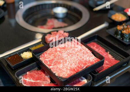 Piatti di carne cruda come il wagyu di prima qualità a fette crude, maiale, sushi e salsa per immersione. Preparato anche per il tradizionale stile barbecue Giapponese Foto Stock