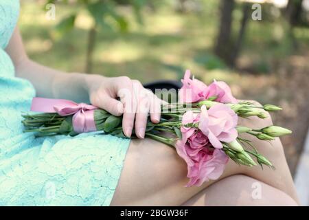 Donna che tiene bel bouquet di fiori di eustoma, all'aperto Foto Stock