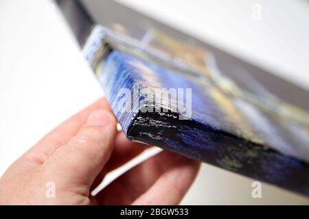 Stampa su tela con tecnica di avvolgimento per il montaggio e lo stiro di tela. Bordo e angolo della foto allungata, primo piano. Industria fotografica Foto Stock