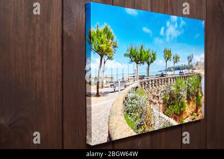 Stampa su tela con tecnica di avvolgimento per il montaggio e lo stiro di tela. Decorazioni a parete. Foto stirata su sfondo di legno marrone. Settore fotografico Foto Stock