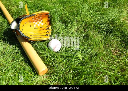 Baseball mazza, palla e guanto su sfondo verde erba Foto Stock