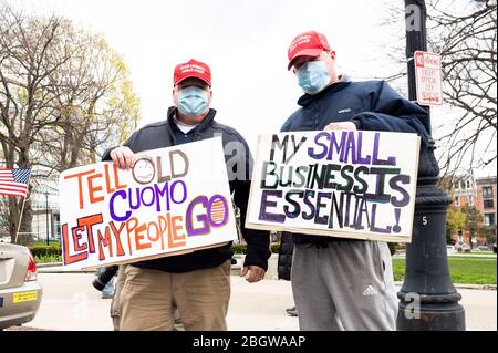 I manifestanti hanno dei cartelli mentre partecipano durante la manifestazione.People si riuniscono al di fuori del New York state Capitol, sostenendo che le normative dello Stato di New York che chiudono parti dell'economia a causa del Coronavirus dovrebbero essere abrogate. Foto Stock