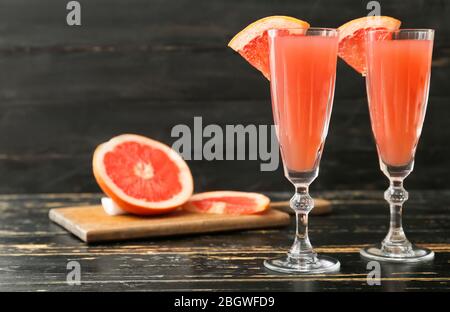 Bicchieri di gustoso cocktail mimosa su sfondo di legno scuro Foto Stock
