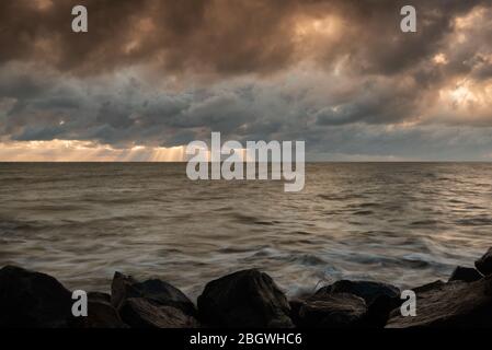 Spiaggia rocciosa con luce temporale cielo nuvoloso i.. Happisburgh, agosto 2018 Foto Stock