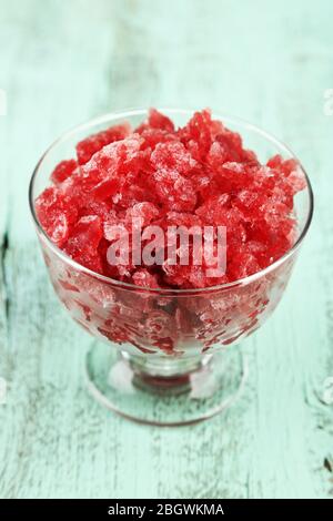 Primo piano di granita di ciliegia in ciotola di vetro, su fondo di legno colorato Foto Stock