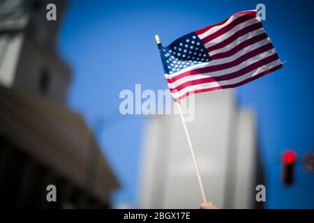 Richmond, Virginia, Stati Uniti. 22 aprile 2020. Una bandiera americana portatile è sventolato durante il Rally Virginia riaperto mercoledì 22 aprile 2020 a Richmond, Virginia. Simili manifestazioni si sono succeduti in giro per gli Stati Uniti a sostegno della riapertura di stati che non sono punti caldi dell'attuale pandemia COVID-19. Credit: John C. Clark/ZUMA Wire/Alamy Live News Foto Stock