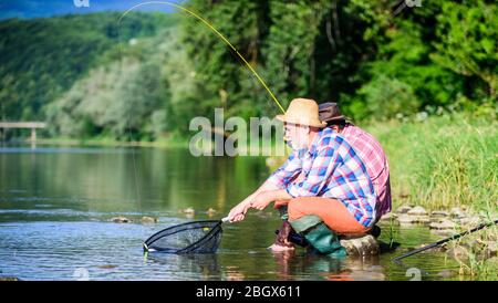 Buon fermo. Uomini bearded pesca. Giornata della famiglia. Fortunato e abile. Cattura di pesce con gli amici. Gli amici catturano il pesce. Altri pescatori. Spinner e affrontare. Bella cattura. Esca e gancio. Hobby e ricreazione. Foto Stock