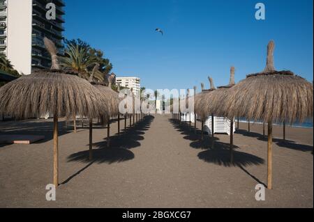 Malaga, Spagna. 22 aprile 2020. Gli ombrelli sono visti in una spiaggia vuota a Marbella, in mezzo alla malattia di scoppio di coronavirus COVID-19. In seguito al confinamento decretato dal governo spagnolo per estendere la chiusura fino al 10 maggio, le persone sono ancora confinate nelle loro case causando una situazione eccezionale di scene urbane insolite come strade vuote o bar, ristoranti e negozi chiusi. Credit: SOPA Images Limited/Alamy Live News Foto Stock