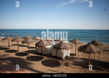 Malaga, Spagna. 22 aprile 2020. Gli ombrelli sono visti in una spiaggia vuota a Marbella, in mezzo alla malattia di scoppio di coronavirus COVID-19. In seguito al confinamento decretato dal governo spagnolo per estendere la chiusura fino al 10 maggio, le persone sono ancora confinate nelle loro case causando una situazione eccezionale di scene urbane insolite come strade vuote o bar, ristoranti e negozi chiusi. Credit: SOPA Images Limited/Alamy Live News Foto Stock