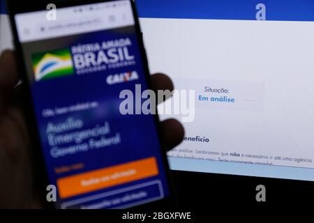 Minas Gerais, MG / Brasile - 22 aprile 2020: Schermo del computer e telefono cellulare con aiuto di emergenza pagina del governo del Brasile, in esame. Foto Stock