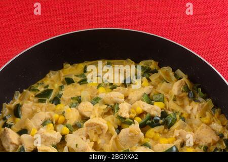 Cottura della base di pollo con pollo tritato, mais, cipolla e peperoni in salsa panna in padella antiaderente Foto Stock