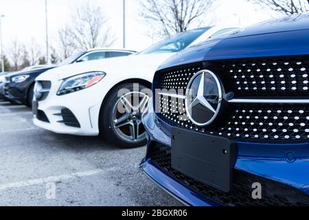 Primo piano dell'emblema Mercedes-Benz su una nuova vettura parcheggiata presso una concessionaria. Foto Stock