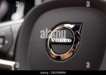 Primo piano del logo/emblema Volvo al centro di un volante in una nuova vettura Volvo. Foto Stock