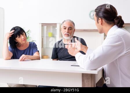 Il consulente finanziario dando consigli di pensionamento alla vecchia coppia Foto Stock