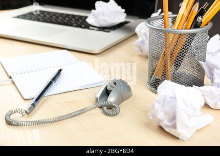 Lavorare in disordine con carta stropicciata e notebook su sfondo tavolo di legno Foto Stock