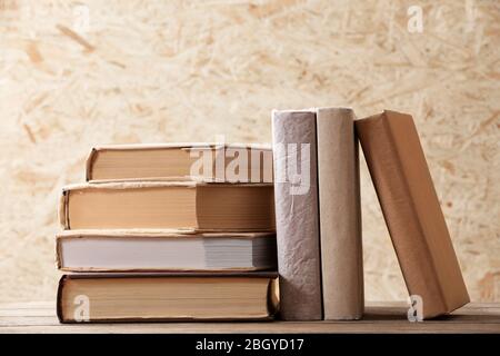 Pila di libri su sfondo di legno duro Foto Stock