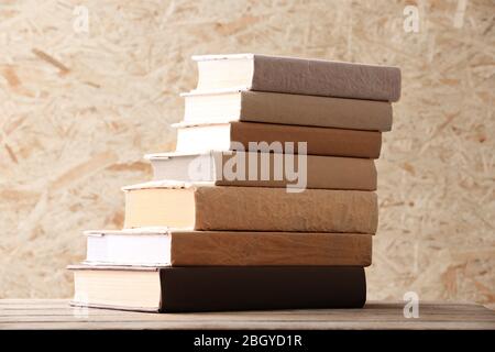 Pila di libri su sfondo di legno duro Foto Stock