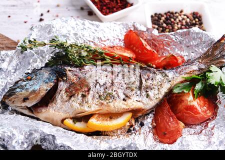 Gustoso pesce al forno in lamina sul tavolo di close-up Foto Stock