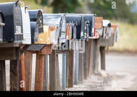 Primo piano di una lunga fila di vecchi e arrugginiti cassette di lettere americane sul marciapiede Foto Stock